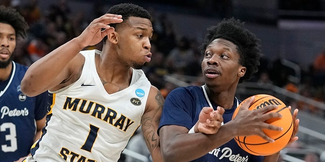 Saint Peter's Jaylen Murray (32) looks to shoot against Murray State's DaQuan Smith (1) during the first half of a college basketball game in the second round of the NCAA tournament, Saturday, March 19, 2022, in Indianapolis.