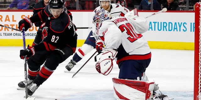 Carolina Hurricanes' Jesperi Kotkaniemi (82) controls the puck as he skates around Washington Capitals goaltender Ilya Samsonov (30) during the second period of an NHL hockey game in Raleigh, N.C., Venerdì, marzo 18, 2022.
