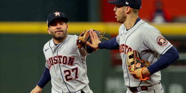 Jose Altuve (27) and Carlos Correa of the Houston Astros celebrate a double play against the Atlanta Braves during the fourth inning in Game Four of the World Series at Truist Park on Oct. 30, 2021, in Atlanta, Georgia.