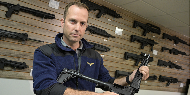 Adrian Kellgren, director of industrial production of KelTec, holds a 9mm SUB2000 rifle, similar to ones being shipped to Ukraine, at their manufacturing facility on Thursday.