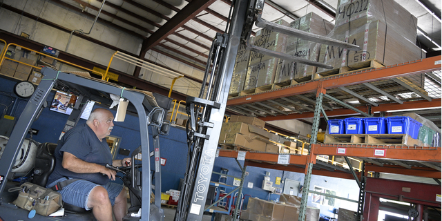 Employee John Marra moves pallets containing a shipment of 9mm SUB2000 rifles awaiting shipment to Ukraine at the KelTec gun manufacturing facility on Thursday.