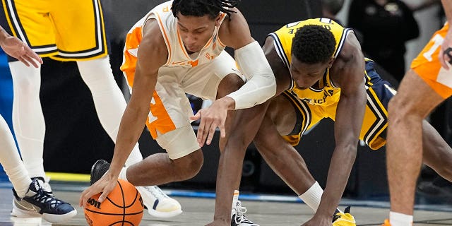 Tennessee's Kennedy Chandler, left, and Michigan's Moussa Diabate battle for the ball in the second round of the NCAA tournament, Saturday, March 19, 2022, in Indianapolis.