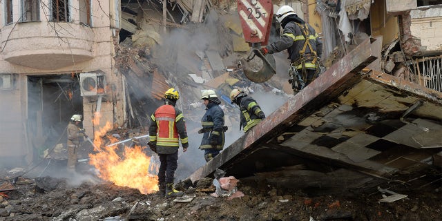 Firefighters work to clear the rubble and extinguish a fire after a Russian rocket exploded in Kharkiv, Ukraine, March 14, 2022.