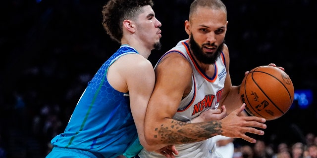 Charlotte Hornets' LaMelo Ball, left, defends against New York Knicks' Evan Fournier during the second half of an NBA basketball game Wednesday, March 30, 2022, in New York.