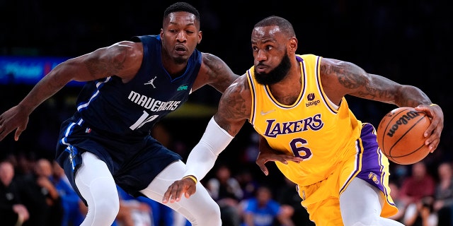 洛杉矶湖人队前锋勒布朗詹姆斯, 对, drives past Dallas Mavericks forward Dorian Finney-Smith during the first half of an NBA basketball game Tuesday, 游行 1, 2022, 在洛杉矶.