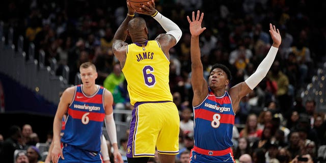 The Los Angeles Lakers' LeBron James (6) fires as Washington Wizards' Rui Hachimura (8) defends during the first half Saturday, March 19, 2022 in Washington.