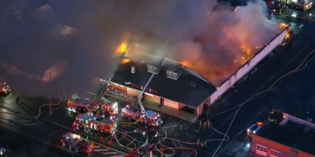Firefighters battles a three-alarm fire that engulfed the Levittown Lanes bowling alley located in Levittown, Pennsylvania, on Wednesday morning.