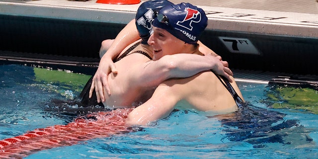 Pennsylvania's Lia Thomas, right, gets a hug from Yale's Iszak Henig after Thomas won the 100-yard freestyle final and Henig finished second at the Ivy League women's swimming and diving championships at Harvard, Saturday, Feb. 19, 2022, in Cambridge, Massachusetts.