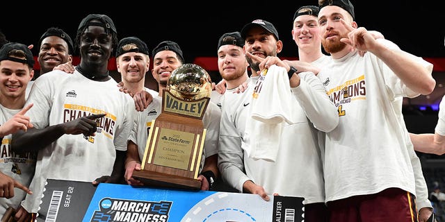 Loyola players pose with the championship trophy after winning the championship game of the Missouri Valley Conference between the Loyola Chicago Ramblers and the Drake Bulldogs March 6, 2022, at Enterprise Center, St. Louis, Mo.