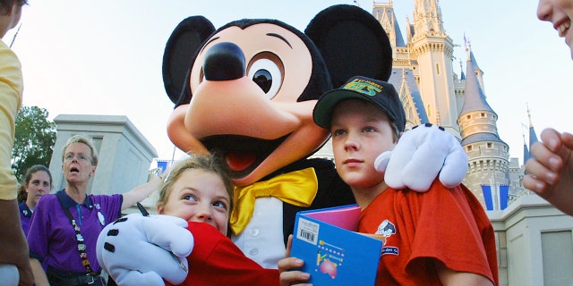 The Walt Disney character Mickey Mouse greets children at the Magic Kingdom in Nov. 11, 2001, in Orlando, Florida. 