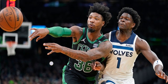 Boston Celtics guard Marcus Smart (36) passes the ball as Minnesota Timberwolves forward Anthony Edwards (1) tries to defend in the first half of an NBA basketball game, Sunday, March 27, 2022, in Boston.