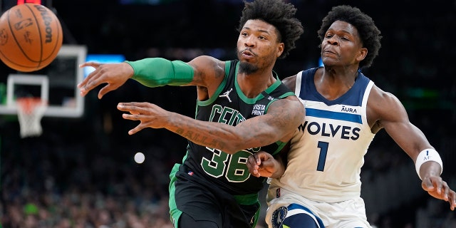 Boston Celtics guard Marcus Smart (36) passes the ball as Minnesota Timberwolves forward Anthony Edwards (1) tries to defend in the first half of an NBA basketball game, Sunday, March 27, 2022, in Boston.