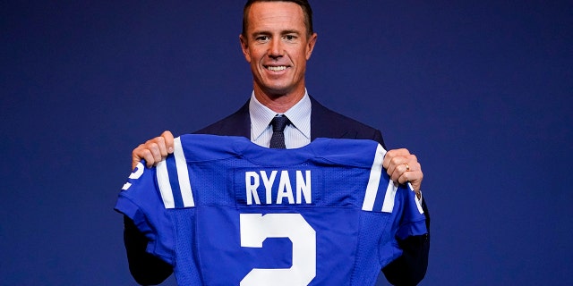 Indianapolis Colts quarterback Matt Ryan holds up his new jersey after a news conference at the NFL team's practice facility in Indianapolis on March 22, 2022.