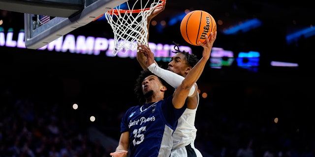 Saint Peter's Matthew Lee, left, goes up for a shot against Purdue's Jaden Ivey during the first half of a college basketball game in the Sweet 16 round of the NCAA tournament, Friday, March 25, 2022, in Philadelphia.