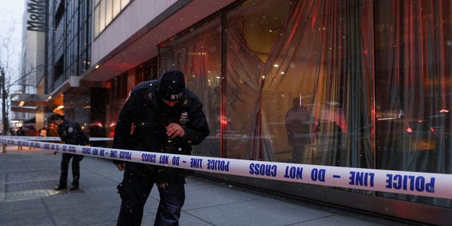 Members of the New York City Police Department (NYPD) search the area near the entrance of the Museum of Modern Art (MOMA) after an alleged multiple stabbing incident, in New York, U.S., March 12, 2022.