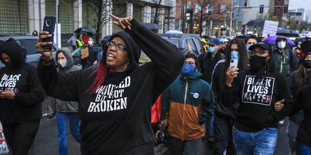Monica Cannon-Grant, front left, leads protesters as they march from Nubian Square to Boston Police Headquarters, April 21, 2021, in Boston, as they celebrate the sentencing of the former police officer of Minneapolis Derek Chauvin and call for an end to police brutality. Federal prosecutors said in a statement Tuesday, March 15, 2022 that Cannon-Grant and her husband Clark Grant, of Taunton, Mass., have been charged in an 18-count indictment of wire fraud, conspiracy and misrepresentation at a mortgage business. (Erin Clark/The Boston Globe via AP)