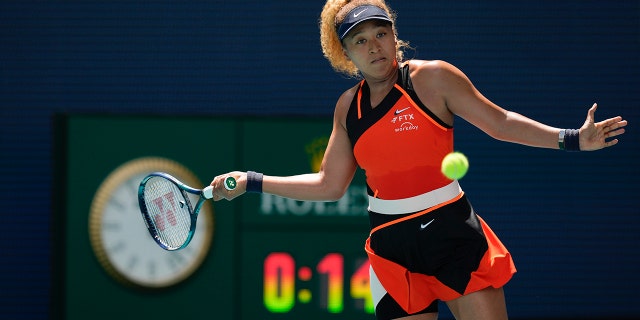 Naomi Osaka of Japan returns a ball against Astra Sharma of Australia in their first round women's match at the Miami Open tennis tournament, Wednesday, March 23, 2022, in Miami Gardens, Fla.