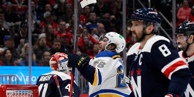 St. Louis Blues left wing Nathan Walker (26) celebrates his goal next to Washington Capitals goaltender Vitek Vanecek (41) and left wing Alex Ovechkin (8) during the second period of an NHL hockey game Tuesday, March 22, 2022, in Washington.