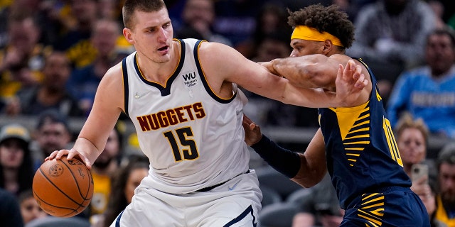 Denver Nuggets center Nikola Jokic (15) drives on Indiana Pacers forward Justin Anderson (10) during the second half of an NBA basketball game in Indianapolis, miércoles, marzo 30, 2022. The Nuggets won 125-118.