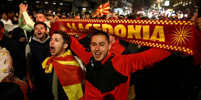North Macedonia's national soccer team fans celebrate the victory against Italy at the World Cup qualifying play-off soccer match, in a street in Skopje, North Macedonia, late Thursday, March 24, 2022.