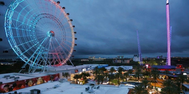 The wheel at ICON Park is on the left, Orlando SlingShot in the middle, and Orlando FreeFall is on the right. A 14-year-old boy died after falling from the Orlando FreeFall ride on March 24.