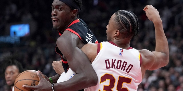 Toronto Raptors forward Pascal Siakam (43) tries to move the ball around Cleveland Cavaliers forward Isaac Okoro (35) during the first half of an NBA basketball game Thursday, March 24, 2022, in Toronto.