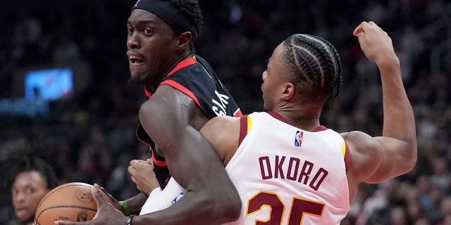 Toronto Raptors forward Pascal Siakam (43) tries to move the ball around Cleveland Cavaliers forward Isaac Okoro (35) during the first half of an NBA basketball game Thursday, March 24, 2022, in Toronto.