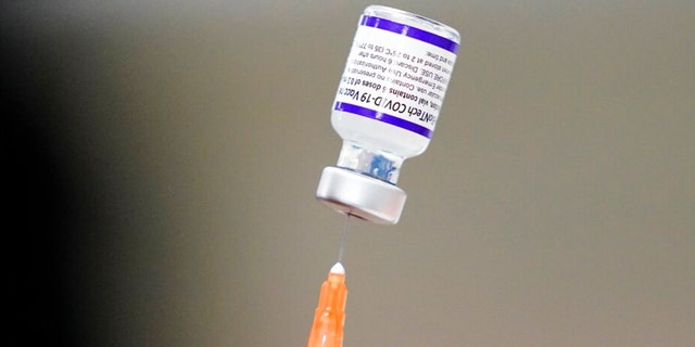 A syringe containing Pfizer's COVID-19 vaccine is prepared at the Keystone First Wellness Center in Chester, Pennsylvania, on December 15, 2021.