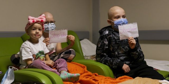 Children patients whose treatments are underway hold papers with the words