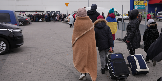 Ukrainian refugees are shown arriving in Poland after having crossed the Poland/Ukraine border. 