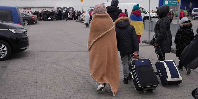 Ukrainian refugees are shown arriving in Poland after having crossed the Poland/Ukraine border. 