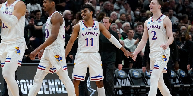 Remy Martin y Christian Braun de Kansas celebran después de la segunda mitad de un partido de baloncesto universitario en la ronda Sweet 16 del torneo de la NCAA contra Providence el viernes 25 de marzo de 2022 en Chicago. Kansas ganó 66-61.