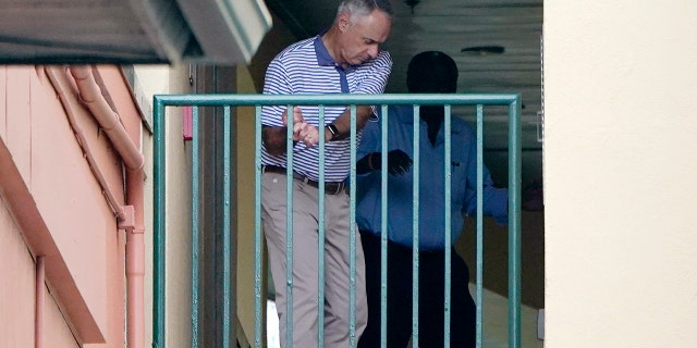 Major League Baseball Commissioner Rob Manfred practices his golf swing as negotiations continue with the players' association toward a labor deal, Tuesday, March 1, 2022, at Roger Dean Stadium in Jupiter, Florida.