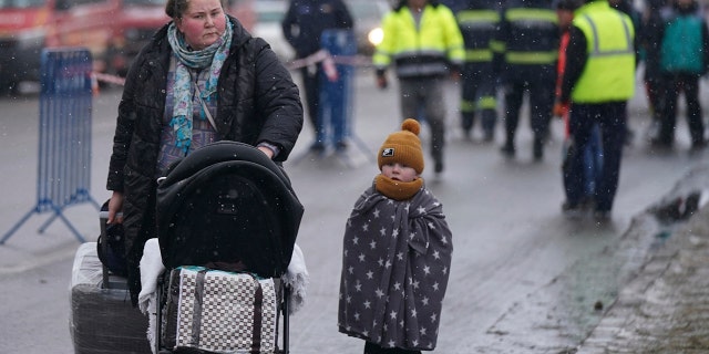 Des personnes traversent la frontière ukrainienne vers Siret, en Roumanie, le mercredi 2 mars 2022, alors qu'elles sont évacuées au milieu de l'invasion russe de l'Ukraine. 