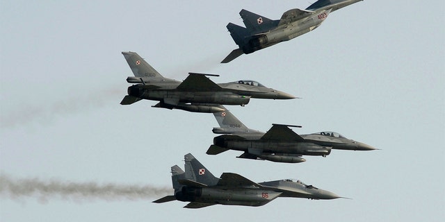 Two Polish Air Force Russian made Mig 29s fly above and below two Polish Air Force U.S. made F-16 fighter jets during the Air Show in Radom, Poland, on Aug. 27, 2011. Ukraine is requesting the U.S. help transfer Polish MiGs to its armed forces.