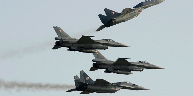 Two Polish Air Force Russian-made Mig 29's fly above and below two Polish Air Force U.S. made F-16's fighter jets during the Air Show in Radom, Poland, on Aug. 27, 2011.