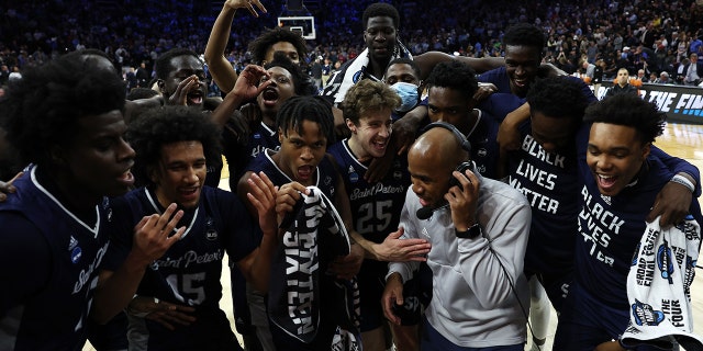 St. Peter's Peacocks players celebrate with head coach Shaheen Holloway after defeating the Purdue Boilermakers 67-64 in the Sweet Sixteen round game of the 2022 セントピーターが走った後、セトンホールはシャヒーンハロウェイに目を向けている 25, 2022 フィラデルフィアで, ペンシルベニア.