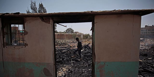 A Yemeni soldier inspects a site of Saudi-led airstrikes targeting two houses in Sanaa, Yemen, Saturday, March 26, 2022. A Houthi media office claimed an airstrike hit houses for guards of the social insurance office, killing at least seven people and wounding three others, including women and children.