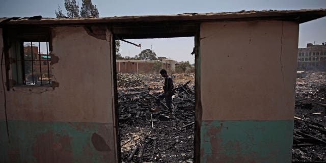 A Yemeni soldier inspects a site of Saudi-led airstrikes targeting two houses in Sanaa, Yemen, Saturday, March 26, 2022. A Houthi media office claimed an airstrike hit houses for guards of the social insurance office, killing at least seven people and wounding three others, including women and children.