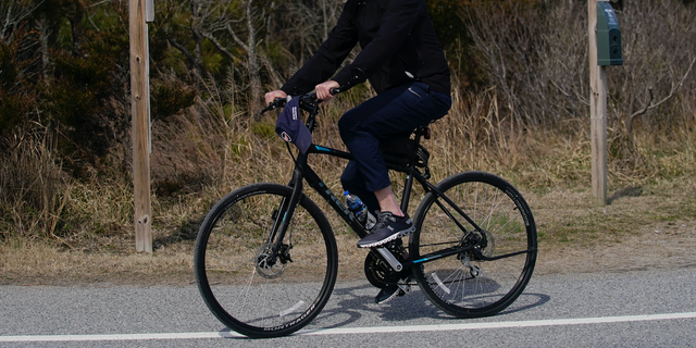 President Joe Biden rides a bicycle in Gordon's Pond State Park in Rehoboth Beach, Del., Sunday, March 20, 2022. (AP Photo/Carolyn Kaster)