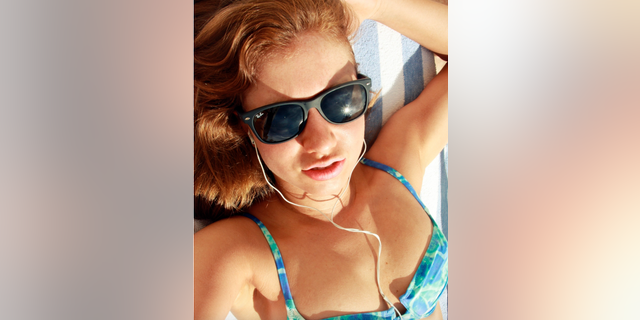 Lauren Pazienza lounges by a pool in an undated photo.