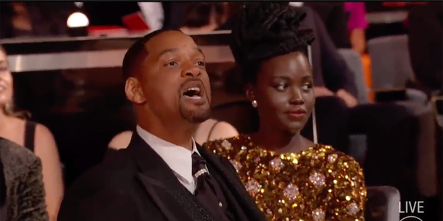 Will Smith grita com Chris Rock de seu assento no Oscar depois de agredi-lo fisicamente no palco no domingo, 27 de março. 