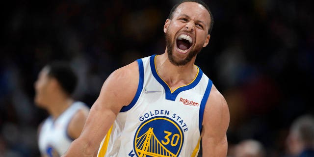 Golden State Warriors guard Stephen Curry reacts after Jordan Poole hit a 3-point basket late in the second half of the team's NBA basketball game against the Denver Nuggets on Thursday, marzo 10, 2022, a Denver.