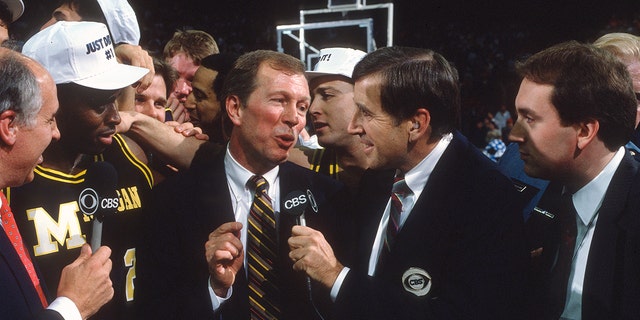 Brent Musburger interviews head coach Steve Fisher of the Michigan Wolverines after the Wolverines defeated the Seton Hall Pirates for the NCAA National Championship on April 3, 1989, at the Kingdome in Seattle, Washington.