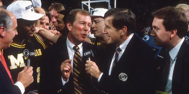 Brent Musburger interviews head coach Steve Fisher of the Michigan Wolverines after the Wolverines defeated the Seton Hall Pirates for the NCAA National Championship on April 3, 1989, at the Kingdome in Seattle, Washington.