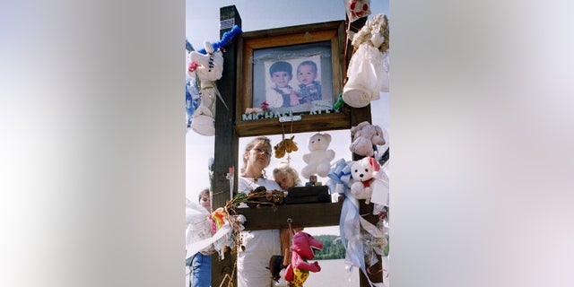 Shelby Hill reads a poem to her daughter Chelsea at the memorial to Alex and Michael Smith at John D. Long Lake near Union,S.C. 