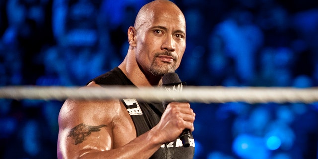 Dwayne Johnson, aka The Rock, enters the ring to talk smack about his upcoming opponent John Cena during the WWE Raw event at Rose Garden arena in Portland, Oregon, Feb. 27, 2012.