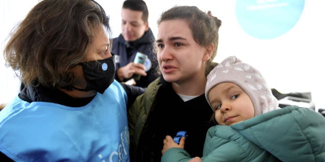 Ukrainian mother Karina and her daughter Luna, 3, are talking to UNICEF's Regional Director for Europe and Central Asia in Romania.