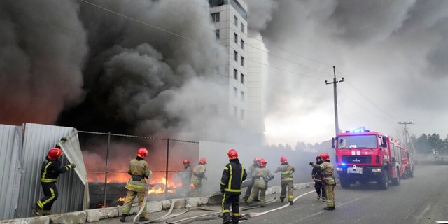 Firefighters work to extinguish a fire at a damaged logistic center after shelling in Kyiv, Ukraine, Thursday, March 3, 2022. (AP Photo/Efrem Lukatsky)