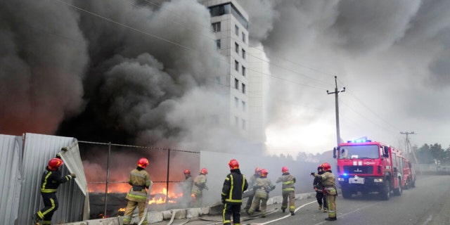 Firefighters work to extinguish a fire at a damaged logistic center after shelling in Kyiv, Ukraine, Thursday, March 3, 2022. Russian forces have escalated their attacks on crowded cities in what Ukraine's leader called a blatant campaign of terror. (AP Photo/Efrem Lukatsky)